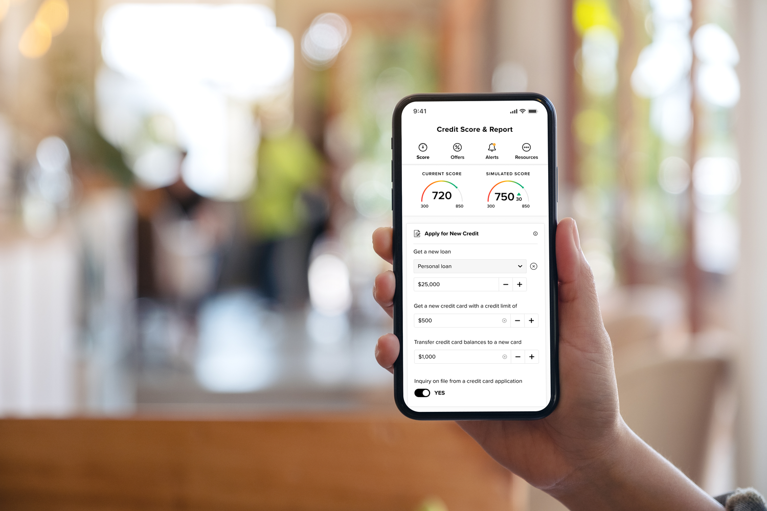 Cell phone in hand with credit score information displayed